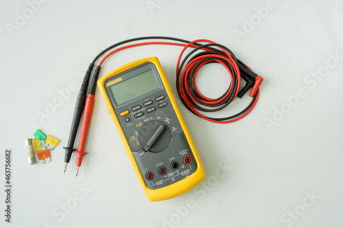 Yellow Digital multimeter with probes on white background , A multimeter is an electronic measuring instrument. 