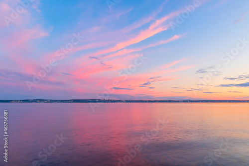 Beautiful colored evening sky after sunset over the horizon with reflection in the water. 