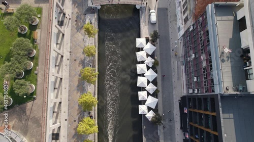 Aerial top forward view of a boat that plows the channel of the city of Aveiro, also known as the Portuguese Venice. Portugal. Slow motion