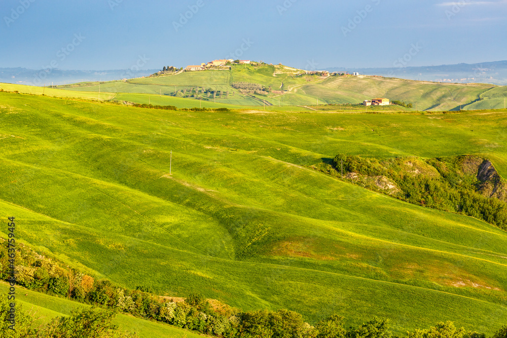 Naklejka premium Small village on a hill with fields in the foreground