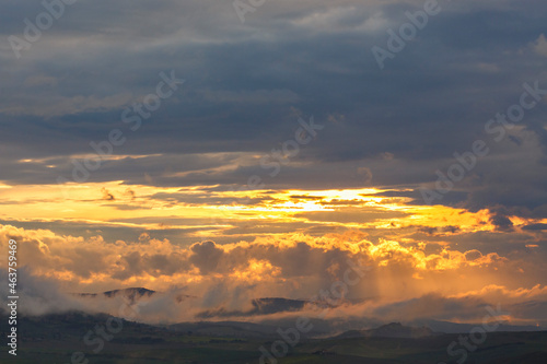 Sunset over mountain landscape with clouds