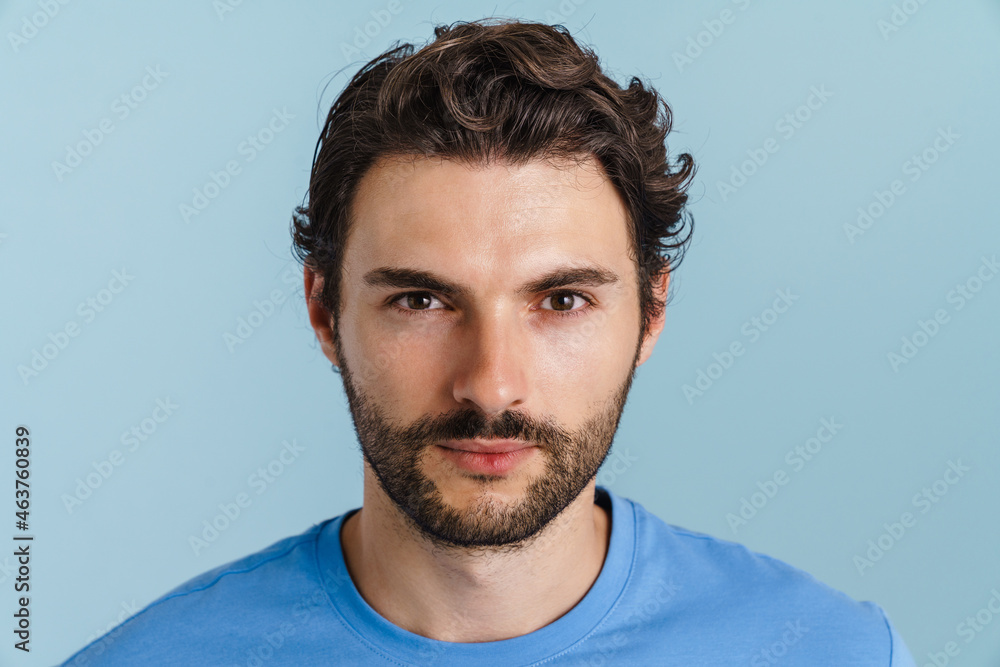 Fototapeta premium Young brunette man with bristle posing and looking at camera