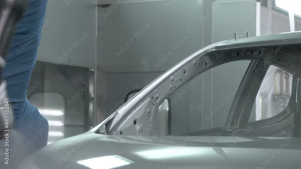 Robotic arms spray painting a vehicle body at a car manufacturing factory Robotic arms spray painting a vehicle body at a car manufacturing factory