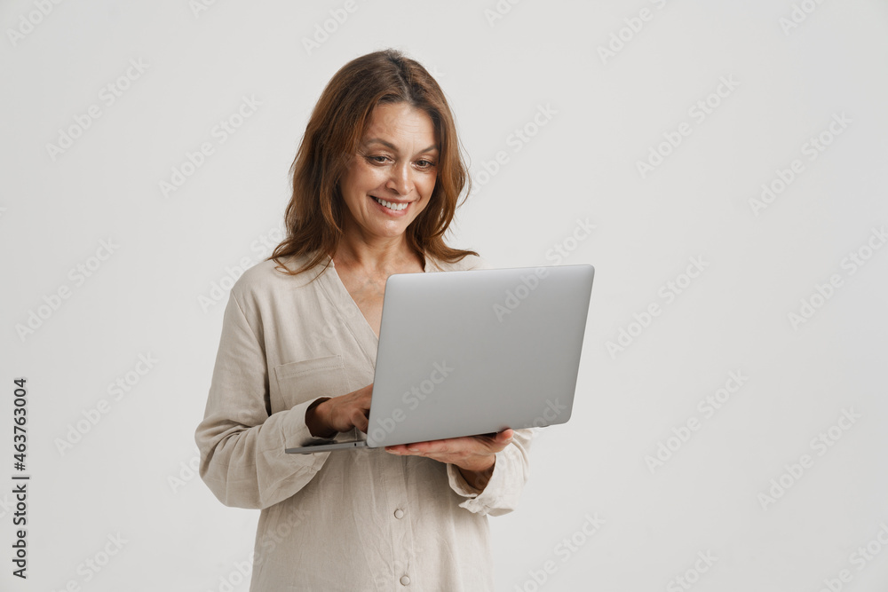 European ginger woman smiling while using laptop European ginger woman smiling while using laptop