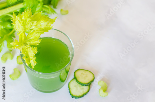 Green, fresh, healthy juice of celery and cucumber in a glass glass on a white background. Close-up. Copy space
