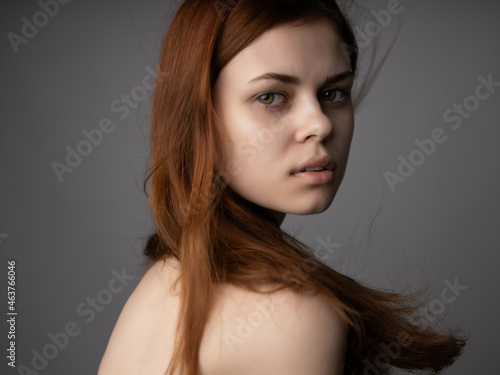 redhead woman bare shoulders clear skin posing studio