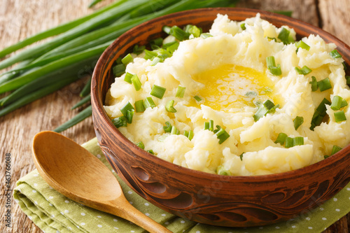 Chopped green onions, milk and a knob of Irish butter champ is a wonderfully delicious alternative to mashed spuds close up in the bowl on the table. Horizontal