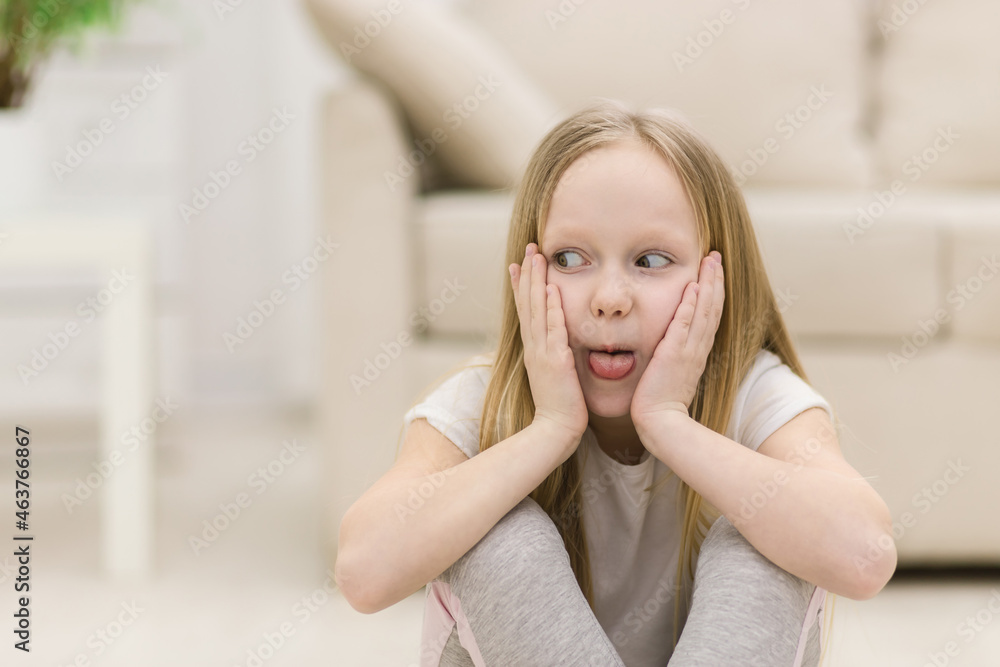 Photo of small blonde girl showing tongue. Photo of small blonde girl showing tongue.