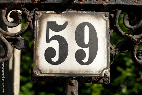 Altes verwittertes Hausnummernschild Nummer Neunundfünfzig und verzierter Metallgartenzaun, Bremen, Deutschland, Europa photo
