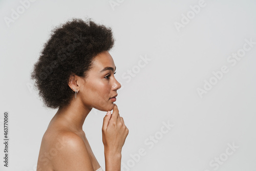 Black young curly woman posing and looking aside