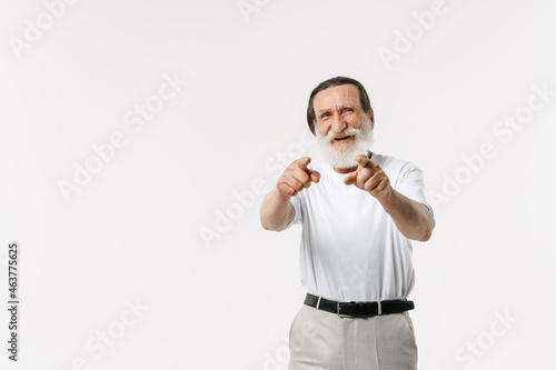 European senior man pointing fingers upward and laughing at camera