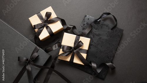 Black Friday sale concept, Gift boxes with black ribbons on black background, top view.