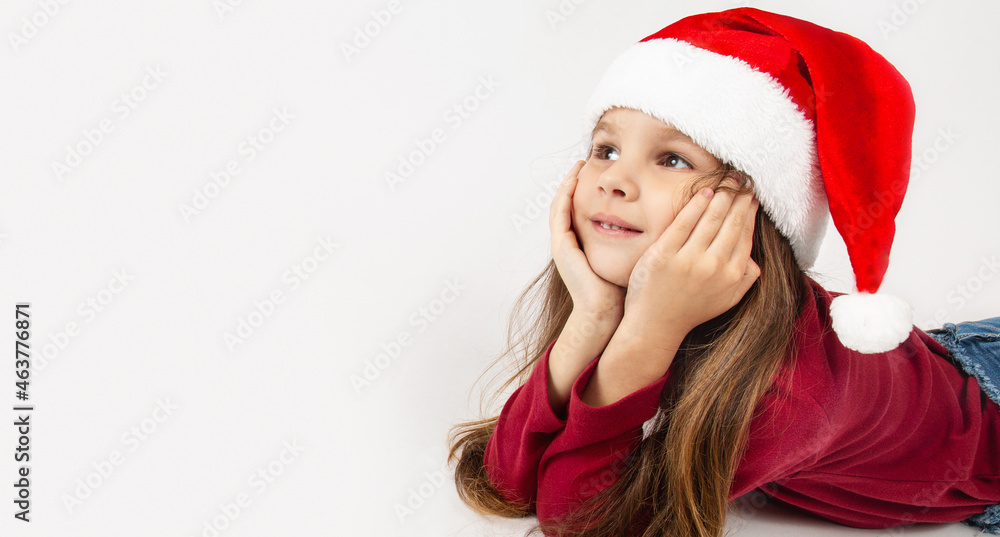 Beautiful little girl with Christmas hat waiting for Santa Claus with a smiling isolated white background. Space for text. Beautiful little girl with Christmas hat waiting for Santa Claus with a smiling isolated white background. Space for text.
