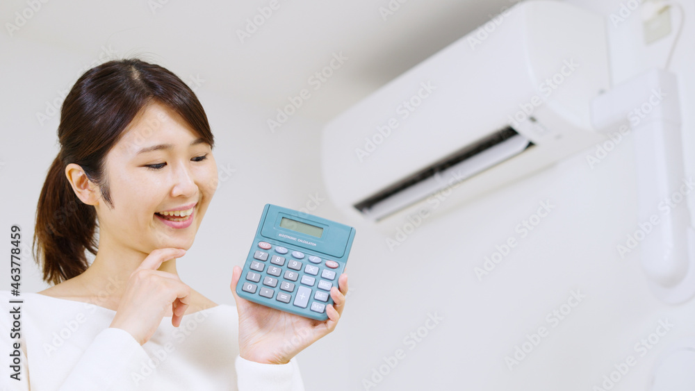 エアコンの電気代について考える女性..