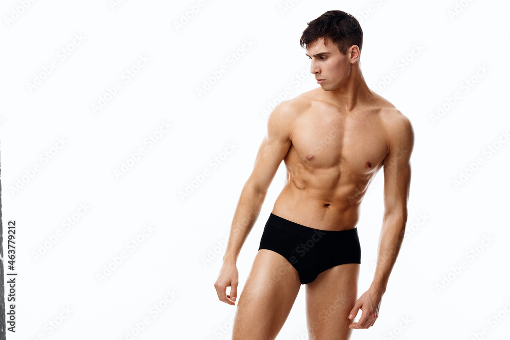 nude male athlete is engaged in fitness on a light background and black panties nude male athlete is engaged in fitness on a light background and black panties