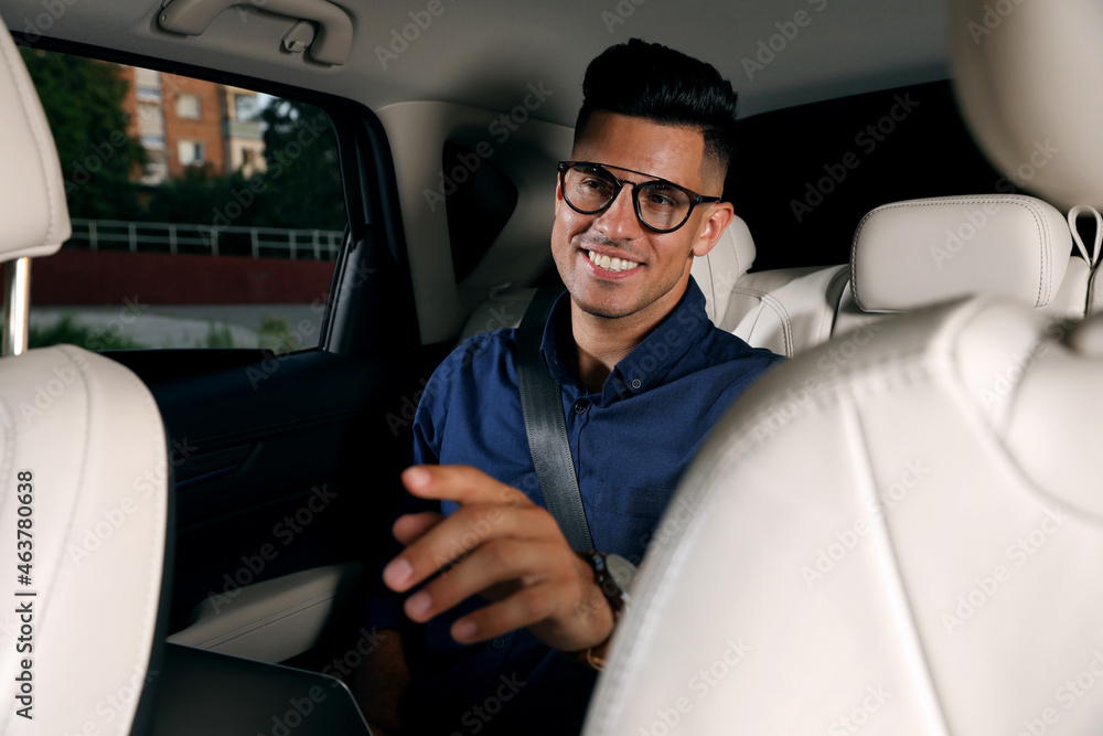Businessman sitting on backseat of modern taxi Businessman sitting on backseat of modern taxi