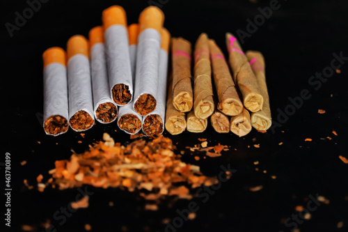 Bidi top detail,Tobacco bidi and cigarettes on black background with tobacco,isolated on black background,broken and whole cigarettes on black table,dry tabacco photo