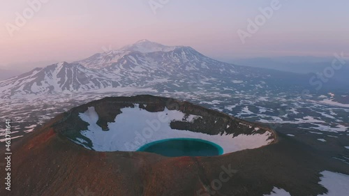 Aerial view of Gorely volcano, Kamchatka. Blue lake inside a crater on a snow-capped mountain top photo