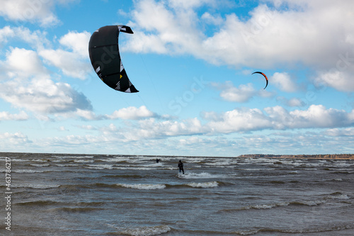 Kitesurfers sails on the background of blue sky and clouds