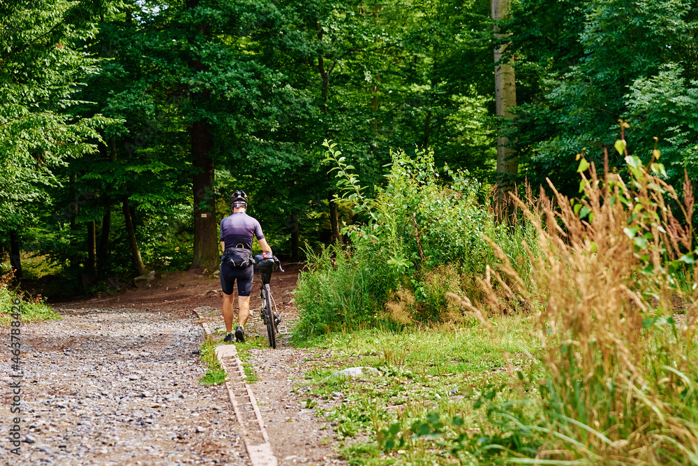 Male athlete ride on bike in forest. Mountain trail. Extreme sport Male athlete ride on bike in forest. Mountain trail. Extreme sport
