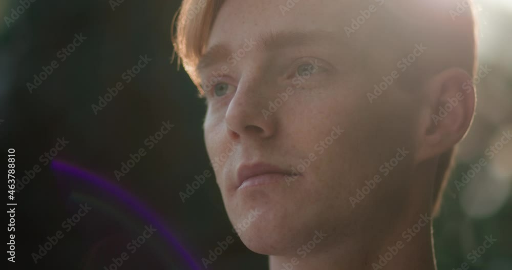 Close up Face of Attractive Redhead Man Opens Eyes and looking ahead at nature. Caucasian Young Ginger Guy having Nice Freckles on Face standing outdoors. Enjoys View. Sunny Background with Bokeh. Close up Face of Attractive Redhead Man Opens Eyes and looking ahead at nature. Caucasian Young Ginger Guy having Nice Freckles on Face standing outdoors. Enjoys View. Sunny Background with Bokeh.
