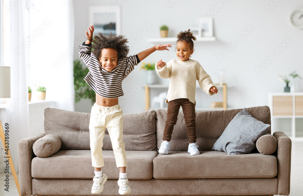 Happy energetic african american children jumping on sofa Stock Photo |  Adobe Stock
