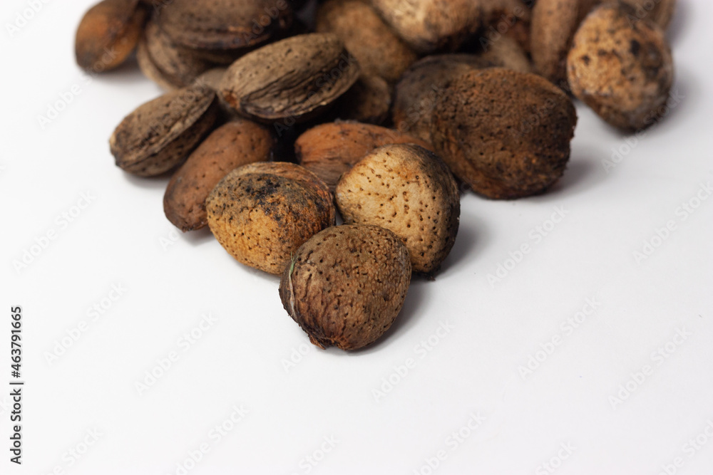 Almendras naturales en cáscara sobre fondo blanco. Concepto comida natural, frutos secos. Almendras naturales en cáscara sobre fondo blanco. Concepto comida natural, frutos secos.