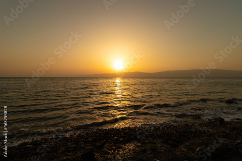 Amazing colors of sunrise over a wild and natural beach in the Dead Sea against the backdrop of the Jordan Mountains