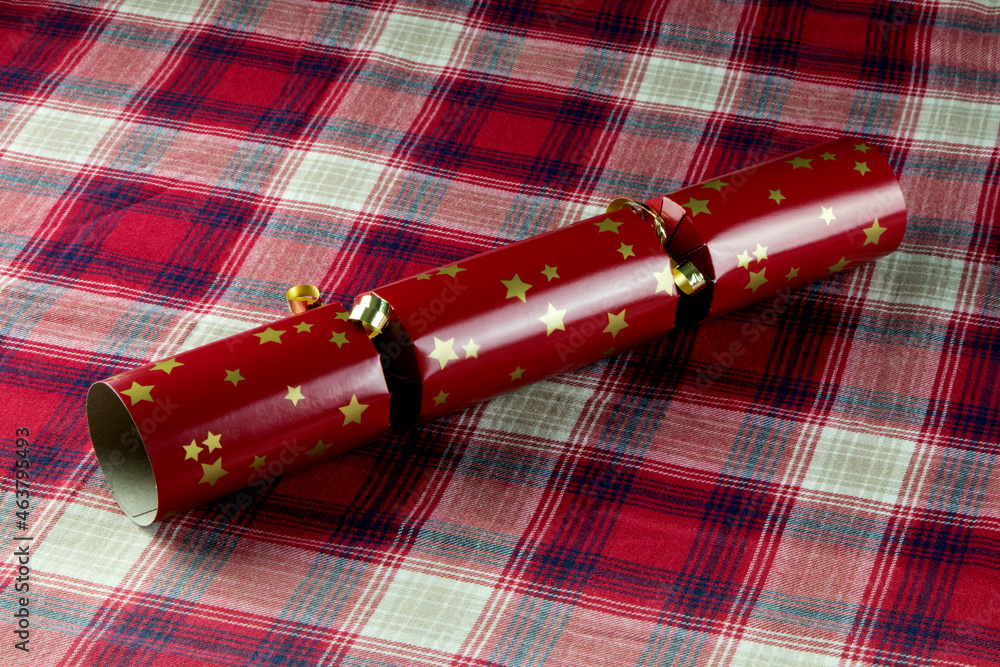 Red Christmas Cracker on a Tartan Table Cloth