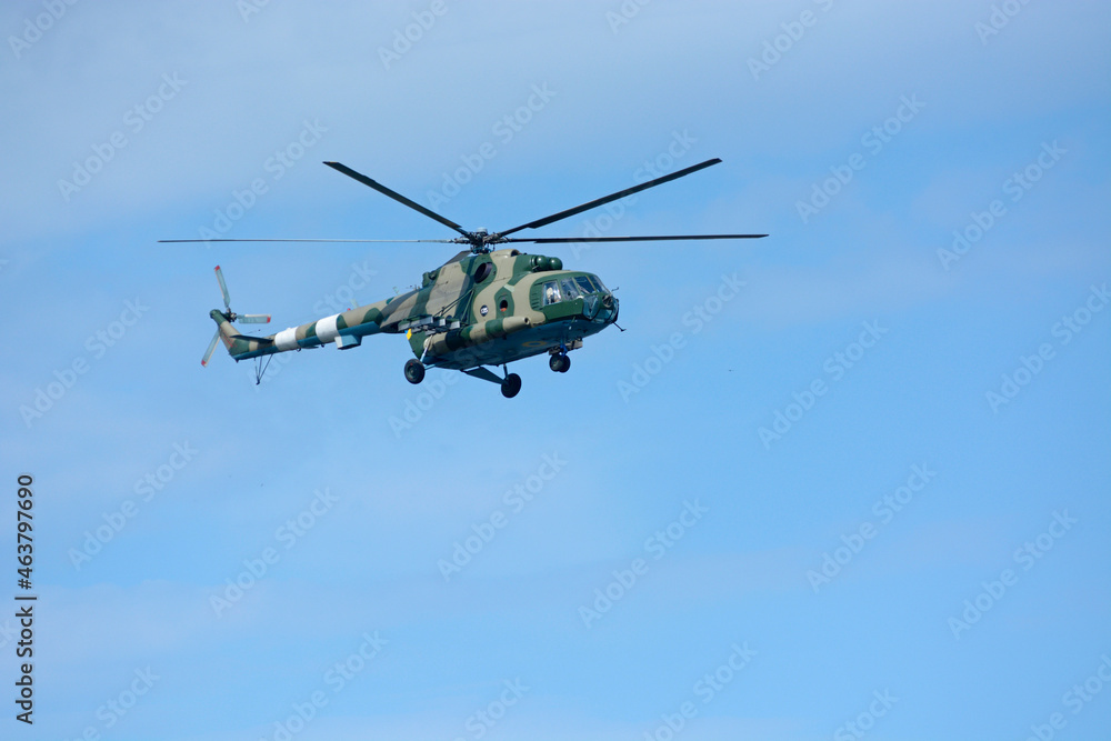 Military battle helicopter flying in a blue sky Military battle helicopter flying in a blue sky