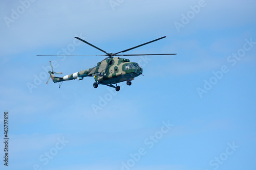 Military battle helicopter flying in a blue sky