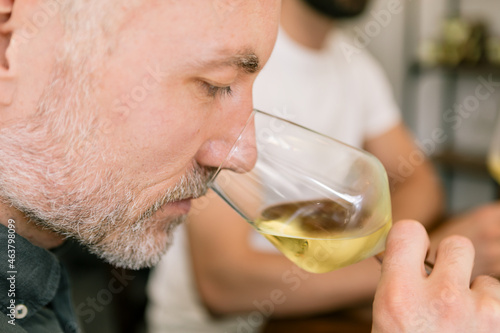 Papier peint sommelier smelling a glass of white wine at the organic and biodynamic wine fair