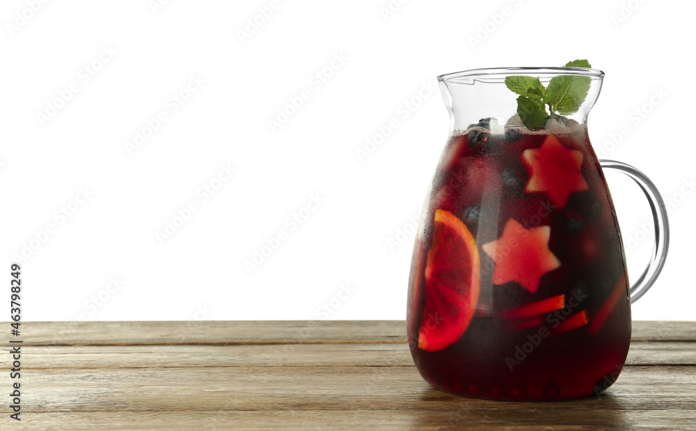 Glass jug of Red Sangria on wooden table against white background. Space for text Glass jug of Red Sangria on wooden table against white background. Space for text