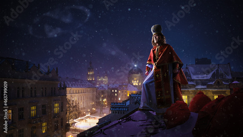 Saint Nicholas - Sinterklaas - Dutch Santa on top of the roof of night winter cityview. High quality photo photo