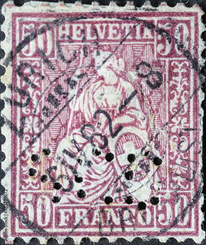 Switzerland - Circa 1881 : a postage stamp from the Switzerland showing the representation of the seated Helvetia the symbol of the Confederation