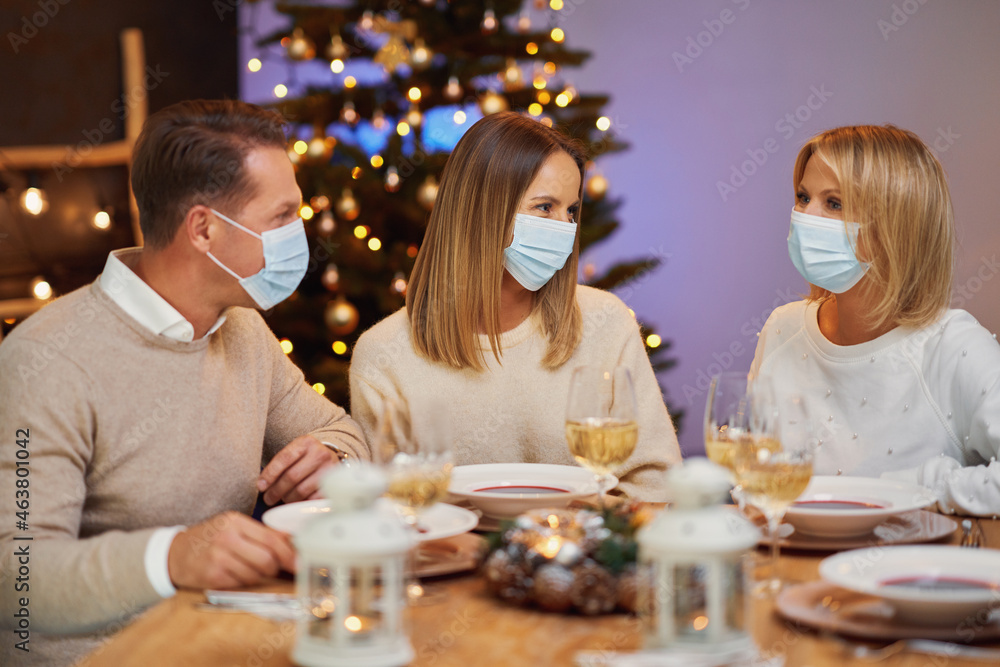 Friends celebrating christmas party wearing mask. Friends celebrating christmas party wearing mask.