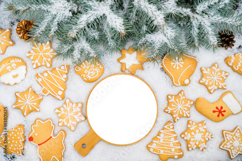 Pattern of gingerbread cookies in different shapes on a snow surface. Top view.