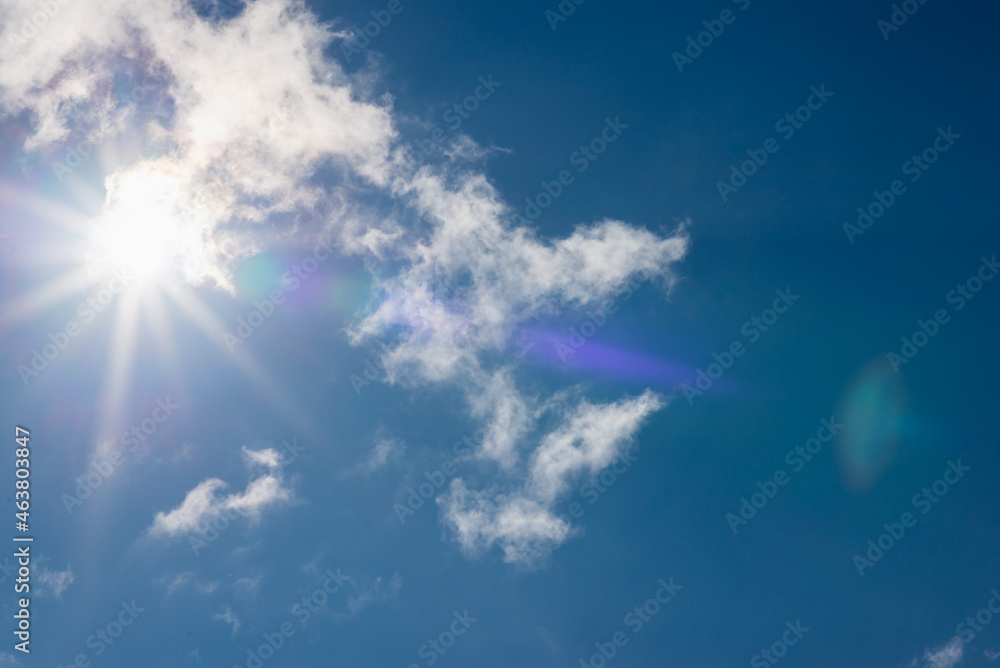 Shining sun through the clouds blue sky,cloud.Solar lens flare. copy space.Natural lens flare.Sunrays of bright sun on summer day. Shining sun through the clouds blue sky,cloud.Solar lens flare. copy space.Natural lens flare.Sunrays of bright sun on summer day.