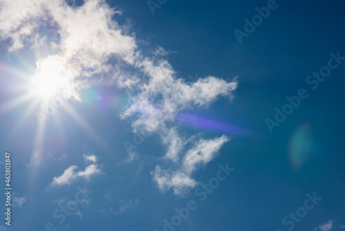 Shining sun through the clouds blue sky,cloud.Solar lens flare. copy space.Natural lens flare.Sunrays of bright sun on summer day. © ARVD73