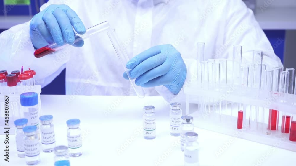 Cropped view of scientist pouring blood in test tube near vaccines in lab Cropped view of scientist pouring blood in test tube near vaccines in lab