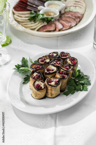 Fried eggplant slices stuffed with soft cheese and pomegranate on the table