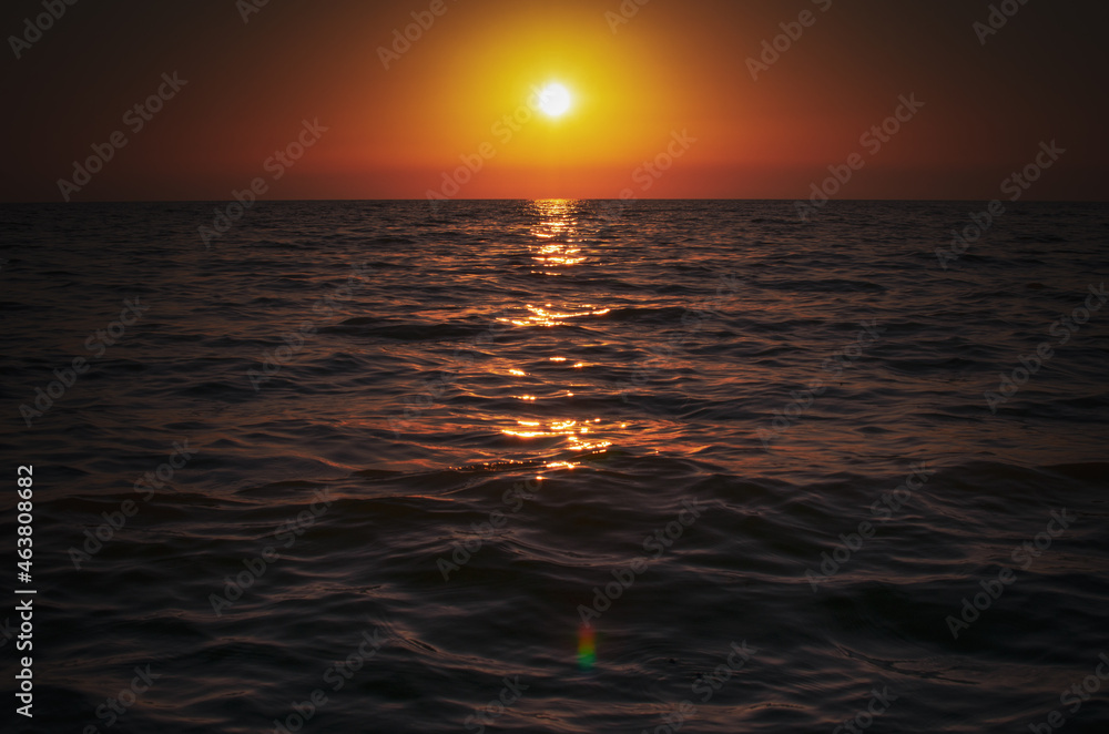 The evening sun setting over the sea horizon