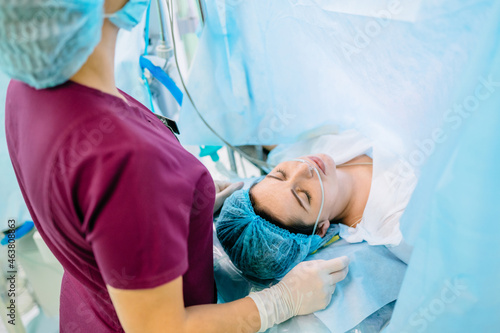 Photos Female octors anesthetist are using tools to anesthesiologist procedures on female patient in the anesthetic machine inside operating room