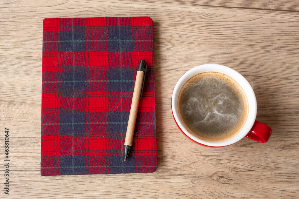 Blank notebook, coffee cup and pen on wood table. Happy New Year, Goals, Resolution, To do list, Strategy and Plan concept Blank notebook, coffee cup and pen on wood table. Happy New Year, Goals, Resolution, To do list, Strategy and Plan concept