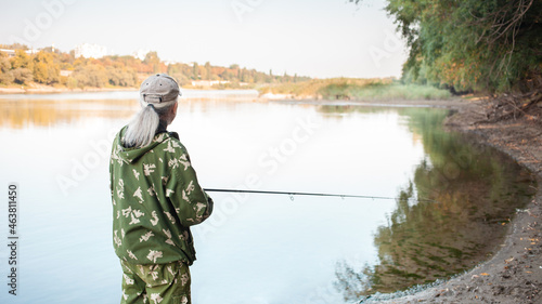 eldest on bank of river, a man with a fishing rod fishing, beautiful nature, autumn. An old man rests and loves his hobby. Active healthy lifestyle, outdoor.
