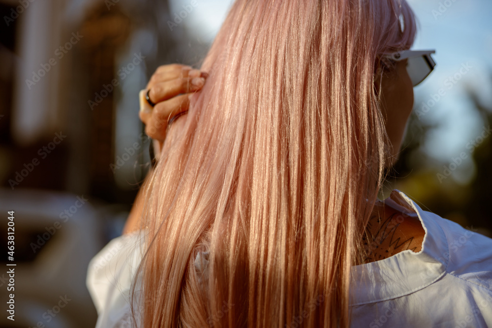 Obraz premium Young woman touching her hair on the street