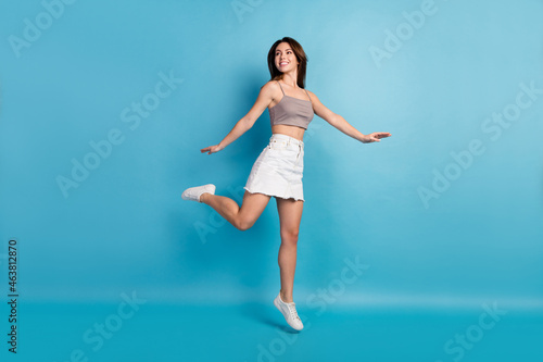 Fototapeta Naklejka Na Ścianę i Meble -  Full size photo of attractive young woman look empty space jump up dream sale isolated on blue color background