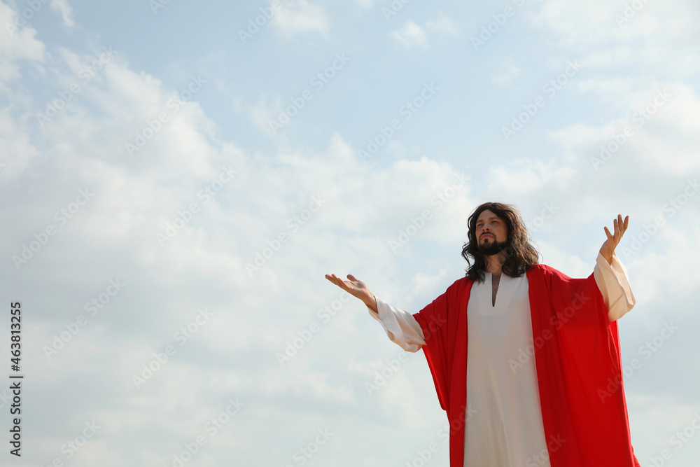 Jesus Christ raising hands against blue sky. Space for text Jesus Christ raising hands against blue sky. Space for text