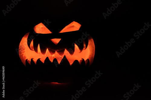 Halloween Head Jack Pumpkin with Scary Smile and Burning Candle Inside for Party Night on Black Background