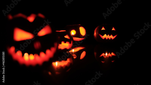 Many Different Halloween Head Jack Pumpkins with Scary Smile and Burning Candle Inside for Party Night on Black Background